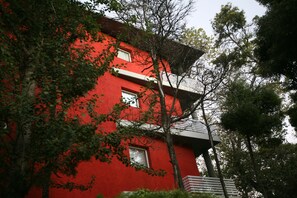 Un bâtiment rouge doté de nombreuses fenêtres et d’un balcon.