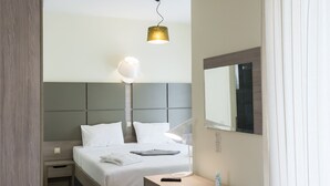 A modern hotel room with a bed, bedside table, lamp, and a small desk with a chair. - Jewel of Venus Villa - Private Pool Paradise (Pylos-Nestoras)