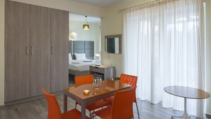 A hotel room with a dining area, a bed, a bedside table, and a large wardrobe. - Jewel of Venus Villa - Private Pool Paradise (Pylos-Nestoras)