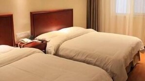 Habitación de hotel con dos camas, cabecero de madera, mesita de noche y un cuadro en la pared.