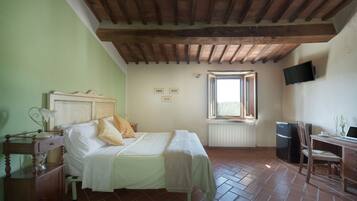 Un dormitorio con cama, mesita de noche, lámpara y ventana.