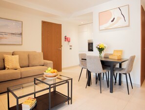 Un salon moderne comprenant un canapé, une table basse et un coin repas avec des chaises et une table.