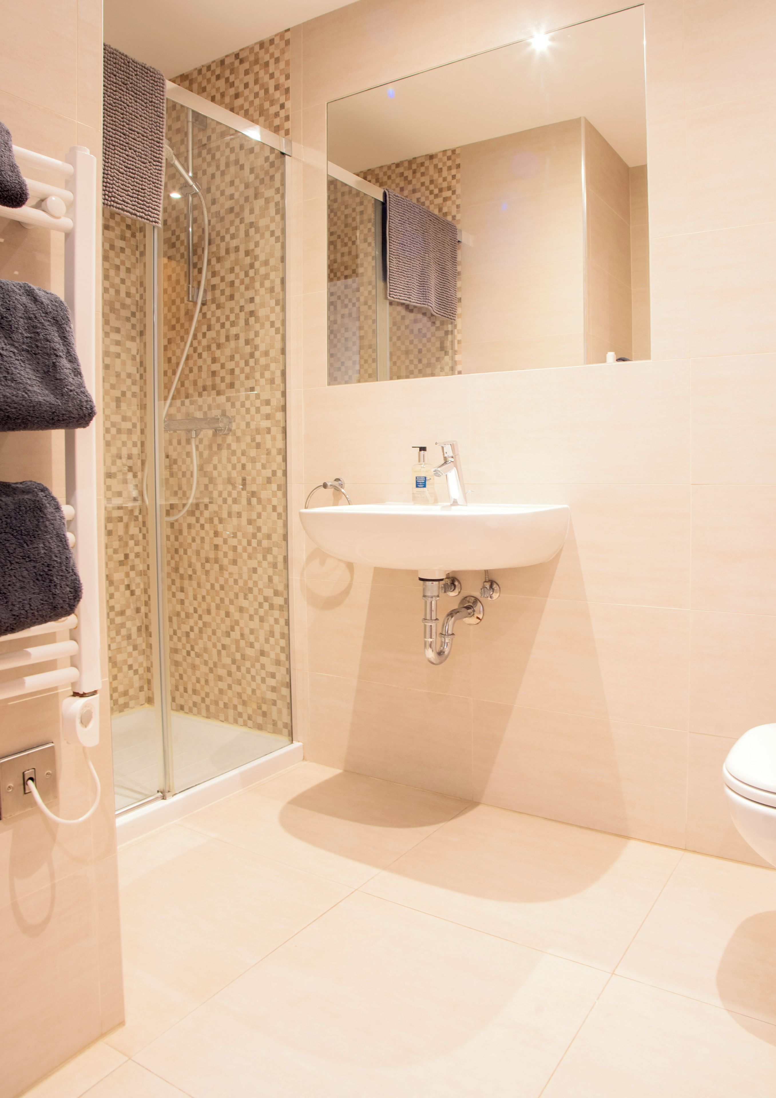 Ein Badezimmer mit Duschkabine, Waschbecken und Toilette.
