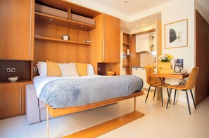 Une chambre à coucher moderne avec un lit, des tables de chevet, un bureau et une chaise.
