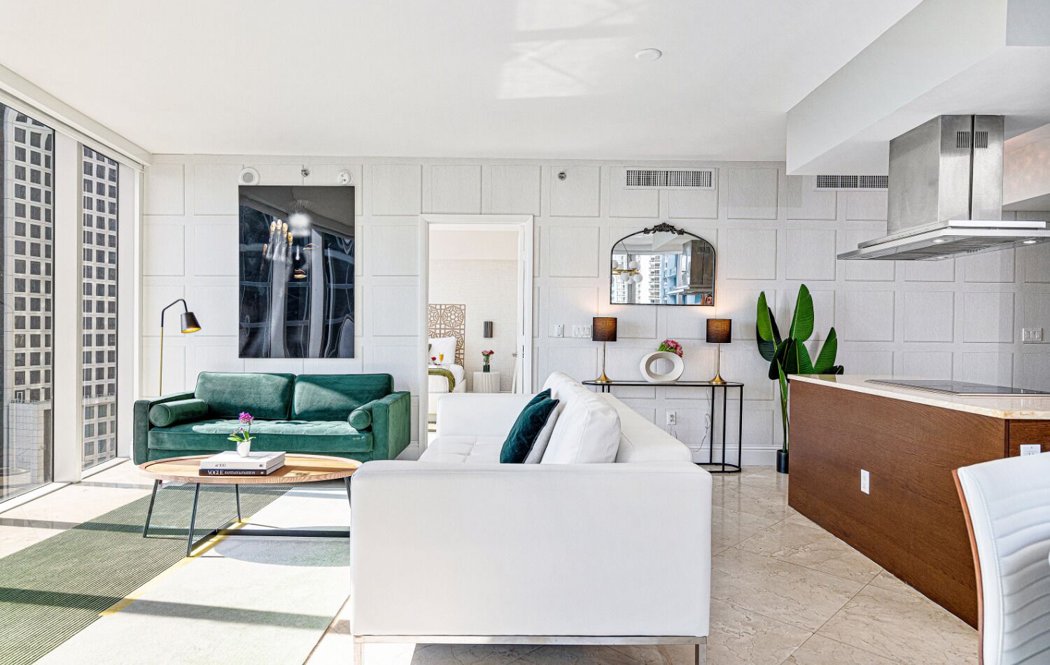 A modern living room with a sofa, coffee table, and a dining area with a kitchen counter.