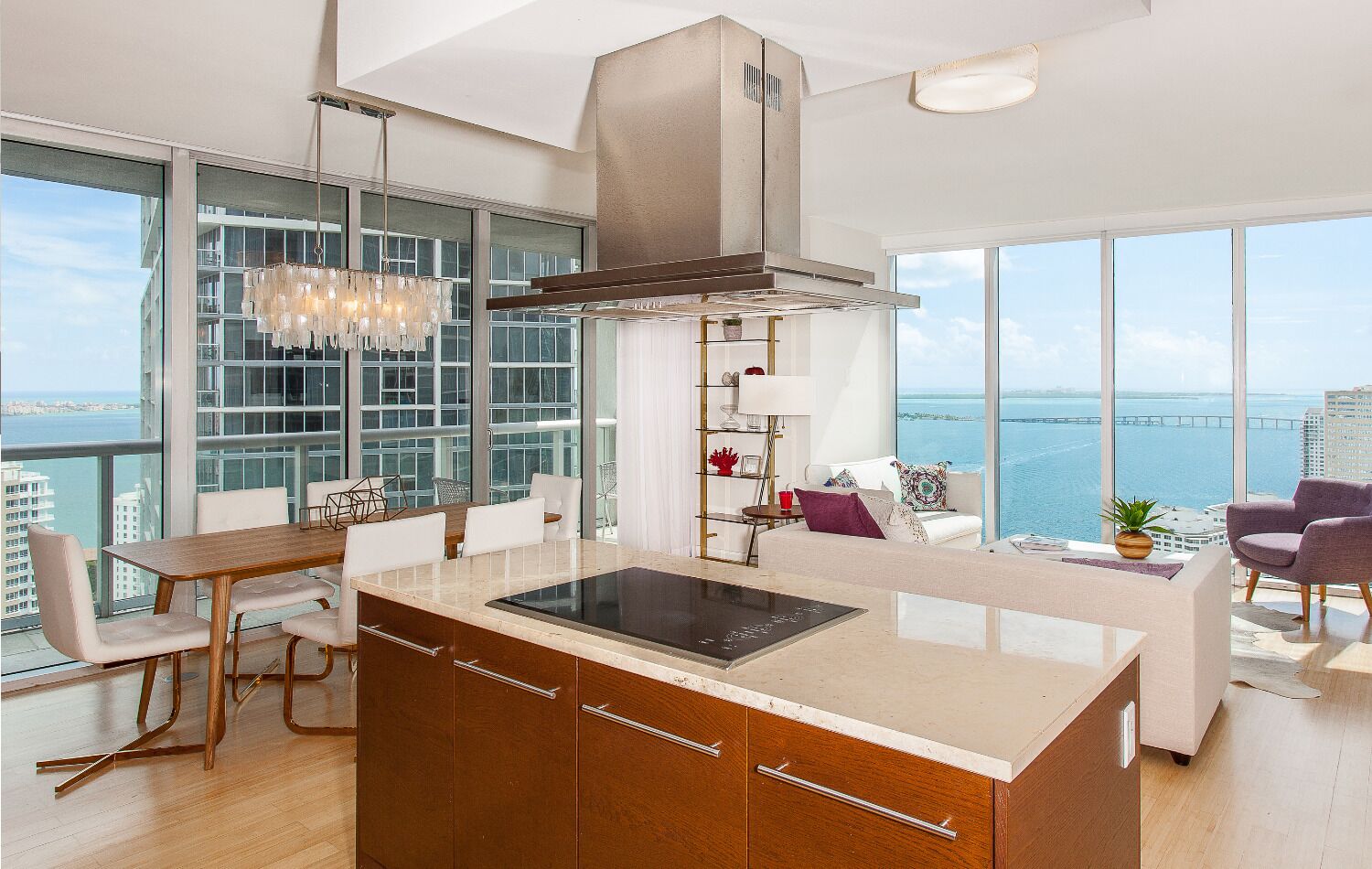 Una cucina moderna con isola centrale, ampie finestre e vista sul mare.