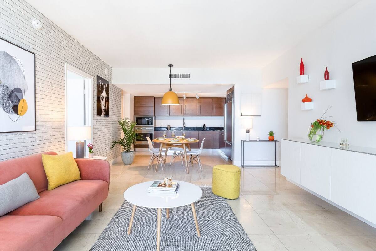 A modern living room with a sofa, coffee table, and dining area.