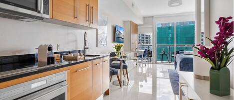 Una cocina moderna con un microondas Bosch, armarios de madera y un comedor con vista a la ciudad.