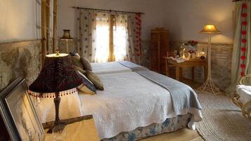 A bedroom with a bed, two lamps, a desk, and a chair.
