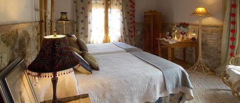 A bedroom with a bed, two lamps, a desk, and a chair.