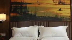 A hotel room with a bed, a headboard, and a painting of a landscape. - The Straits Times Hotel (Fuzhou)
