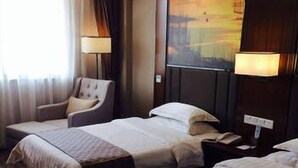 A hotel room with two beds, a chair, a lamp, and a painting on the wall. - The Straits Times Hotel (Fuzhou)