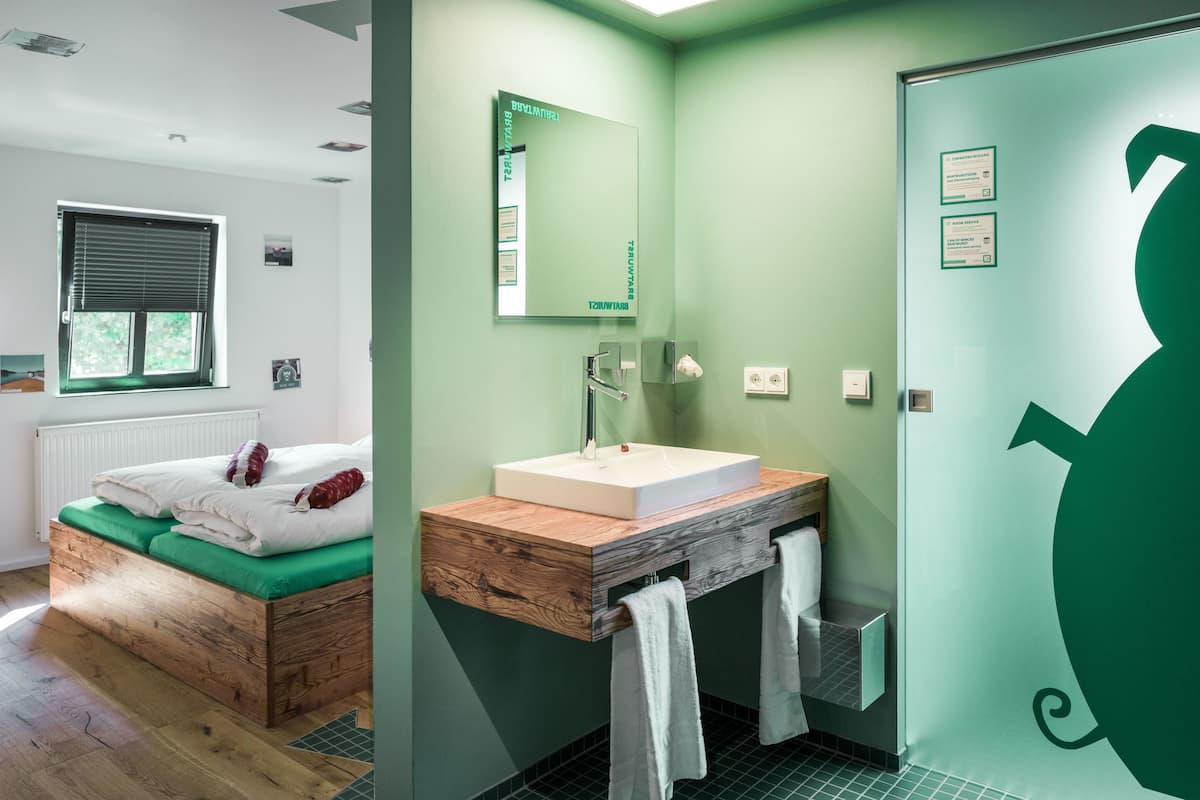 Ein modernes Badezimmer mit einem Holzbadezimmer, einem großen Spiegel und einer grünen Wand.