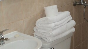 A bathroom with a sink, toilet, and stacked towels. - Departamentos Arlenne II (Valdivia)