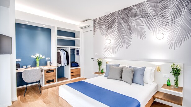 A modern bedroom with a large bed, a desk, and a wardrobe. - Victor Boutique Hotel (Milan)