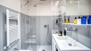 A modern bathroom with a glass-enclosed shower, a white sink, and a mirror above the sink. - Victor Boutique Hotel (Milan)