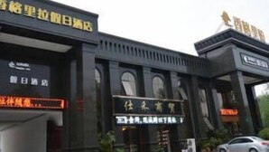 A hotel entrance with a large sign and a smaller sign below it. - Xinzheng Shangri-la Holiday Hot Spring Hotel (Zhengzhou)