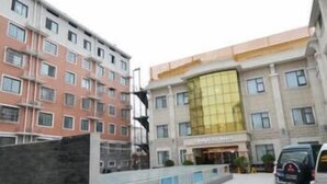 A multi-story hotel with a modern facade, featuring a mix of balconies and large windows. - Xinzheng Shangri-la Holiday Hot Spring Hotel (Zhengzhou)