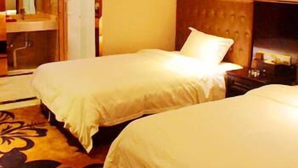 A hotel room with two beds, a large mirror, and a painting on the wall. - Xinzheng Shangri-la Holiday Hot Spring Hotel (Zhengzhou)