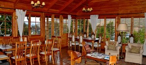 Eine Holzhütte mit großen Fenstern, Holzmöbeln und einer Kandelaber.