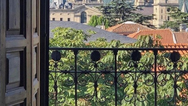 A view of a building with multiple domes and a balcony with a wrought iron railing. - San Lorenzo Suites (San Lorenzo de El Escorial)