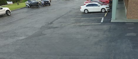 Un parking avec plusieurs voitures et un bateau.