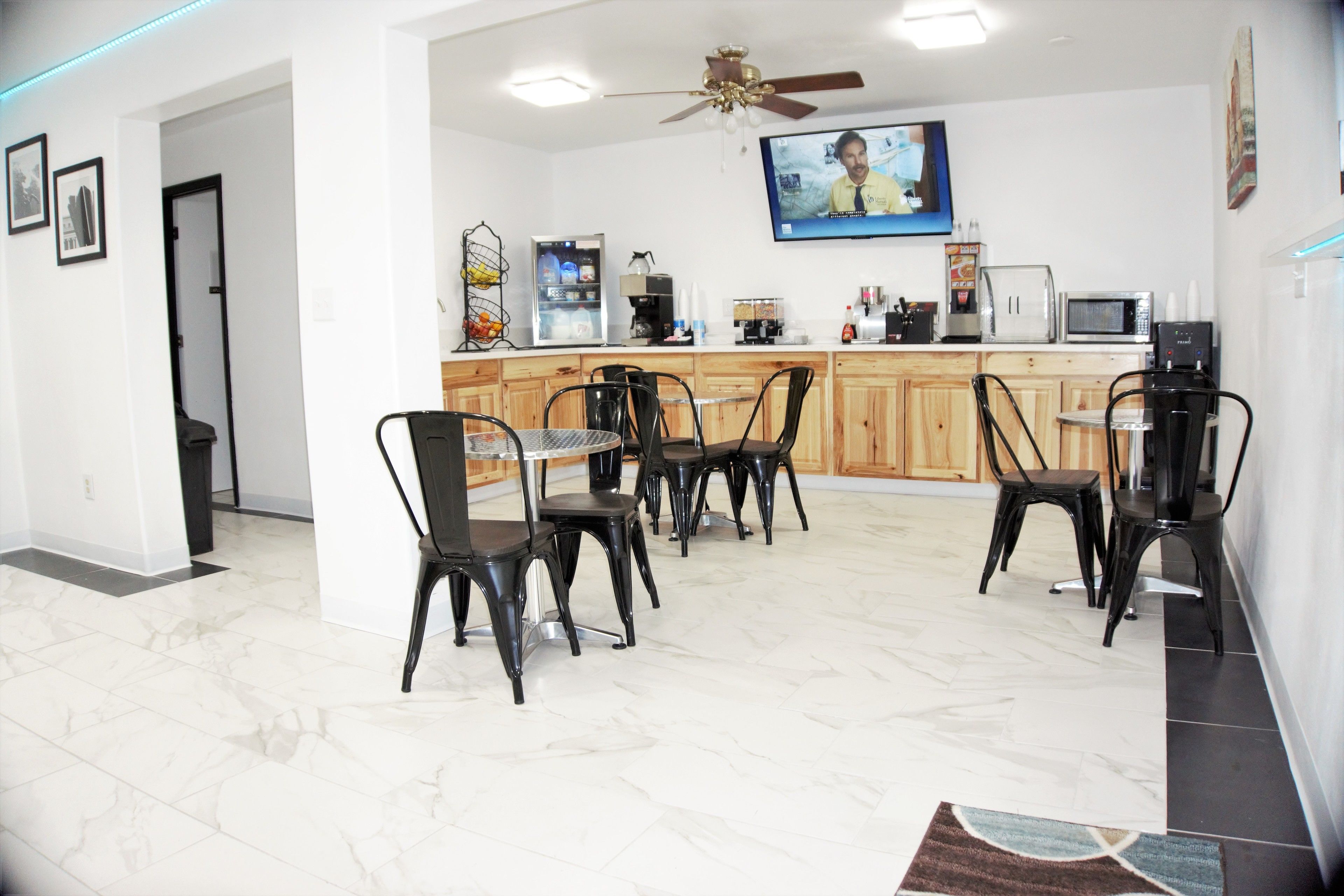 A modern kitchen with a dining area, equipped with a coffee machine, microwave, and refrigerator.