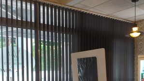 A restaurant interior with a partition wall, a dining table, chairs, and a hanging light fixture. - Hotel Fin De Semana (Gandia)