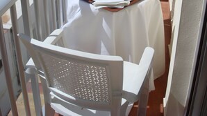 A balcony with a table set for breakfast, including croissants, orange juice, and coffee. - Hotel Fin De Semana (Gandia)