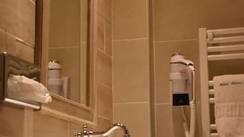 A bathroom with a sink, mirror, and towel rack.