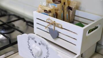 A kitchen with a white appliance containing bags of groceries.