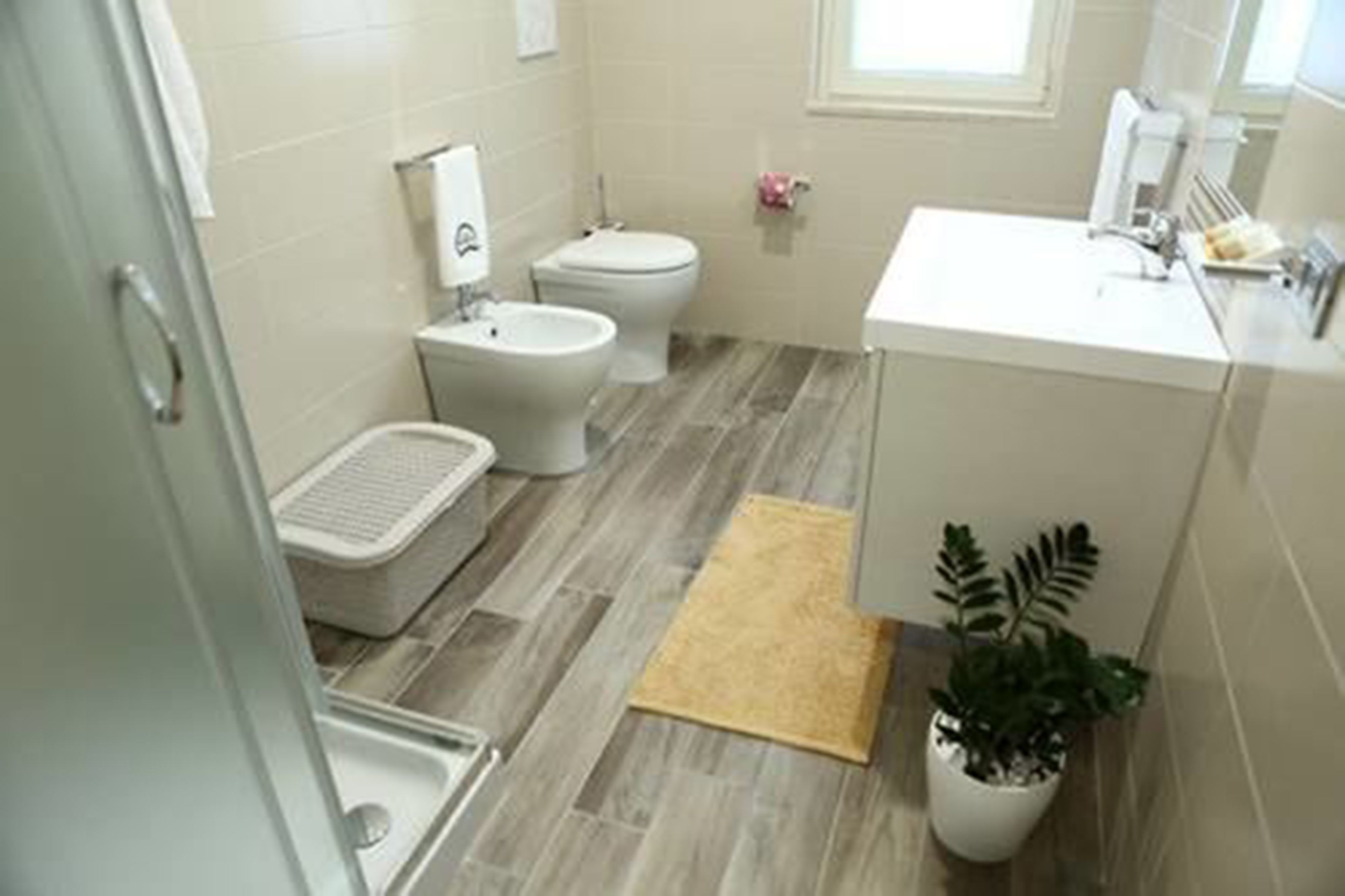 Un baño moderno con bidé, inodoro y lavamanos.