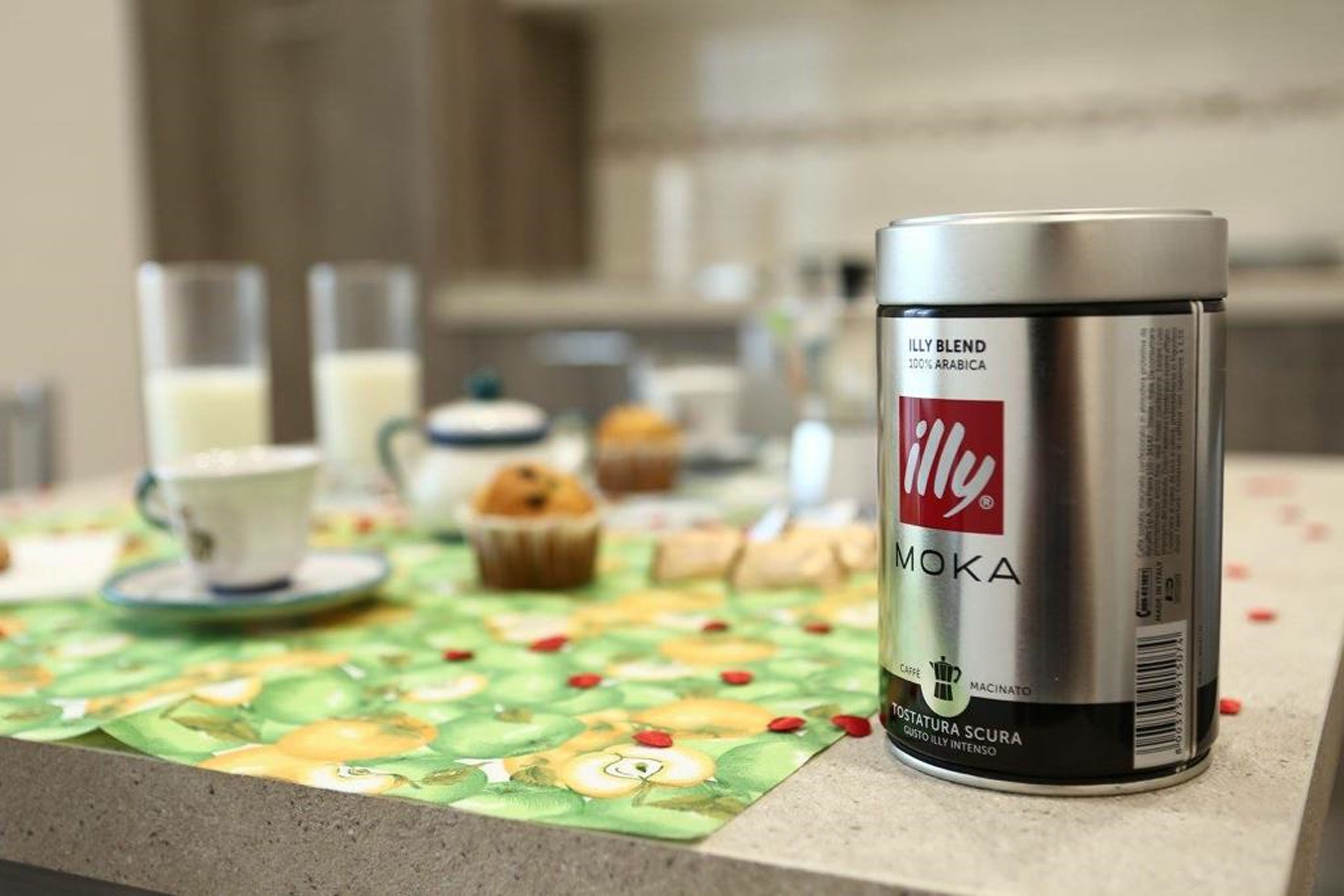 A coffee maker on a kitchen counter with a placemat featuring fruit designs.