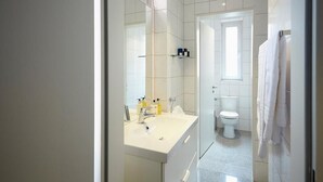 A modern bathroom with a large sink, mirror, and toilet. - Aparthotel TU-TU (Essen)