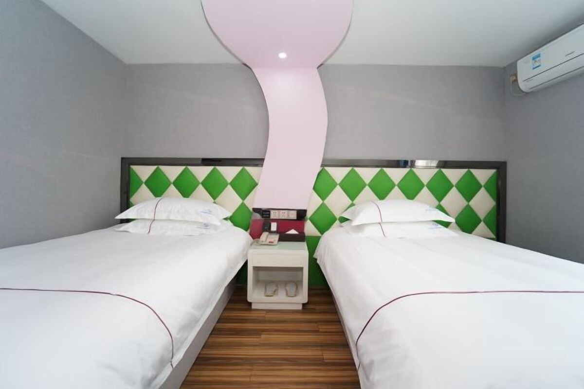 Ein Hotelzimmer mit zwei Einzelbetten, einem Nachttisch mit Telefon und einem außergewöhnlichen Deckengestalt.