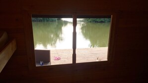 Una ventana con vistas a un cuerpo de agua tranquilo y un muelle.
