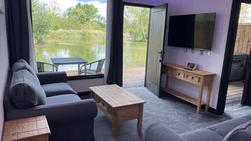 Suite Premium, 2 habitaciones, hidromasaje, vista al lago | Área de sala de estar | Televisión de pantalla plana de 55 pulgadas con canales digitales