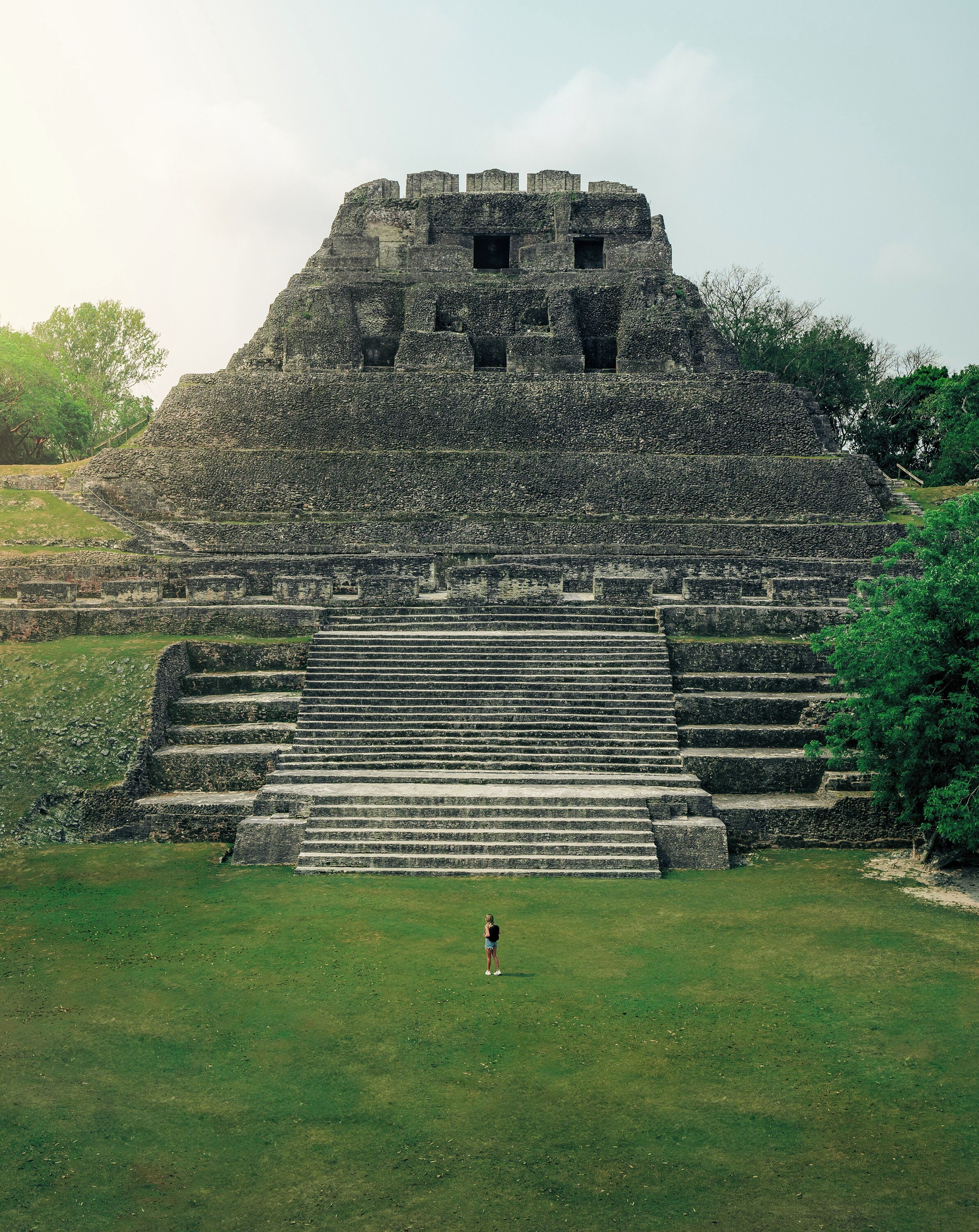 A large stone pyramid with multiple levels and a staircase leading up to it.