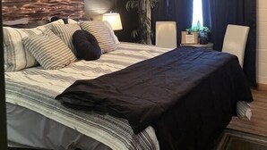Un dormitorio con cama, mesita de noche, lámpara, planta en maceta y un cartel que dice 'RMHOUSE'.