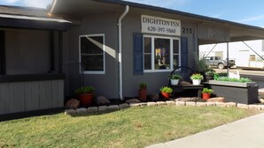 Ein Motel mit einem Schild, auf dem 'DIGHTON INN 620-397-5860 215' steht und der Ziffer '215' am Gebäude.
