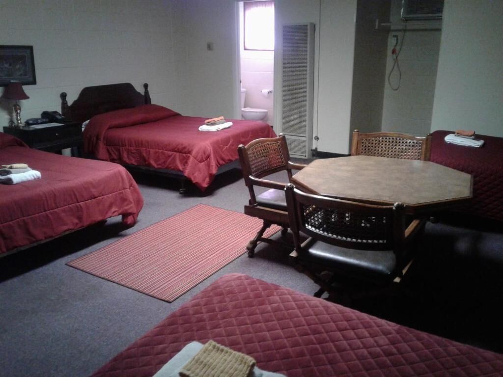 Une chambre d’hôtel avec deux lits simples, une table ronde et une chaise.