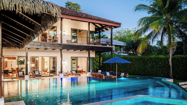 A two-story house with a swimming pool, outdoor seating, and a thatched roof structure. - Perfect Family Retreat with the best Sunset views: Luxury Beachfront house w/ Pool & Heated Jacuzzi (Hacienda Pinilla)