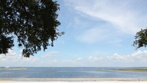 Eine Küstenansicht mit sandigem Strand und ruhiger See.