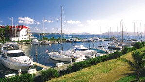 A marina with various boats docked, a building with a red roof, and a clear blue sky. - Sapphire Beachfront Renovated Villa 1200 SF! - Free Wi-Fi, Generator (St Thomas)