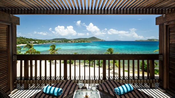 A wooden deck with a view of a beach and ocean. - Sapphire Beachfront Renovated Villa 1200 SF! - Free Wi-Fi, Generator (St Thomas)