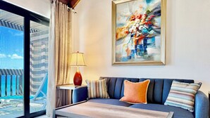 A modern living room with a sofa, coffee table, and a painting on the wall. - Sapphire Beachfront Renovated Villa 1200 SF! - Free Wi-Fi, Generator (St Thomas)