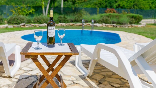 A poolside setting with a table, two glasses, and a bottle of wine. - Wonderful private villa with WIFI, private pool, A/C, TV, terrace, pets allowed and panoramic view (Buzet)