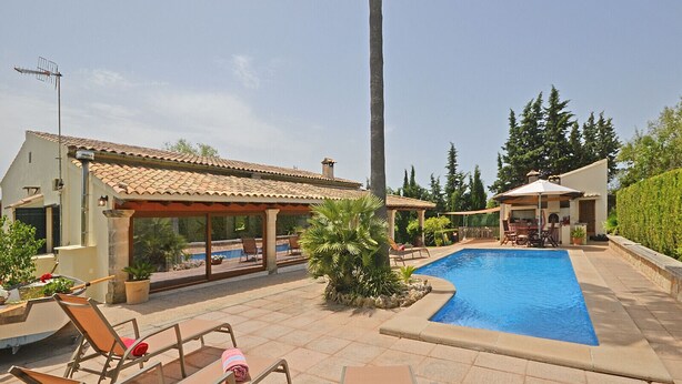 A backyard with a swimming pool, lounge chairs, and a covered patio area. - Es Pou - Charming villa with pool in Biniamar, Selva, Mallorca (Selva)