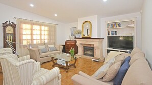 A living room with a fireplace, a television, and a bookshelf. - Es Pou - Charming villa with pool in Biniamar, Selva, Mallorca (Selva)