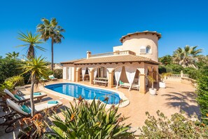 A Mediterranean-style villa with a swimming pool, sun loungers, and lush tropical plants. - V. Son Serra, Pool & Chill Out by BeBreeze (Son Serra de Marina)